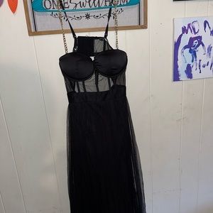 Floor length black dress, gold chain straps, the bottom has two slits in it